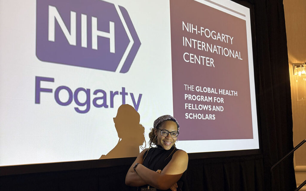A photo of a student standing in front of a presentation.