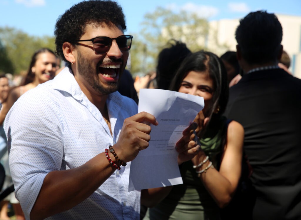 Anthony Martinez holding his match paper celebrating and looking happy. 