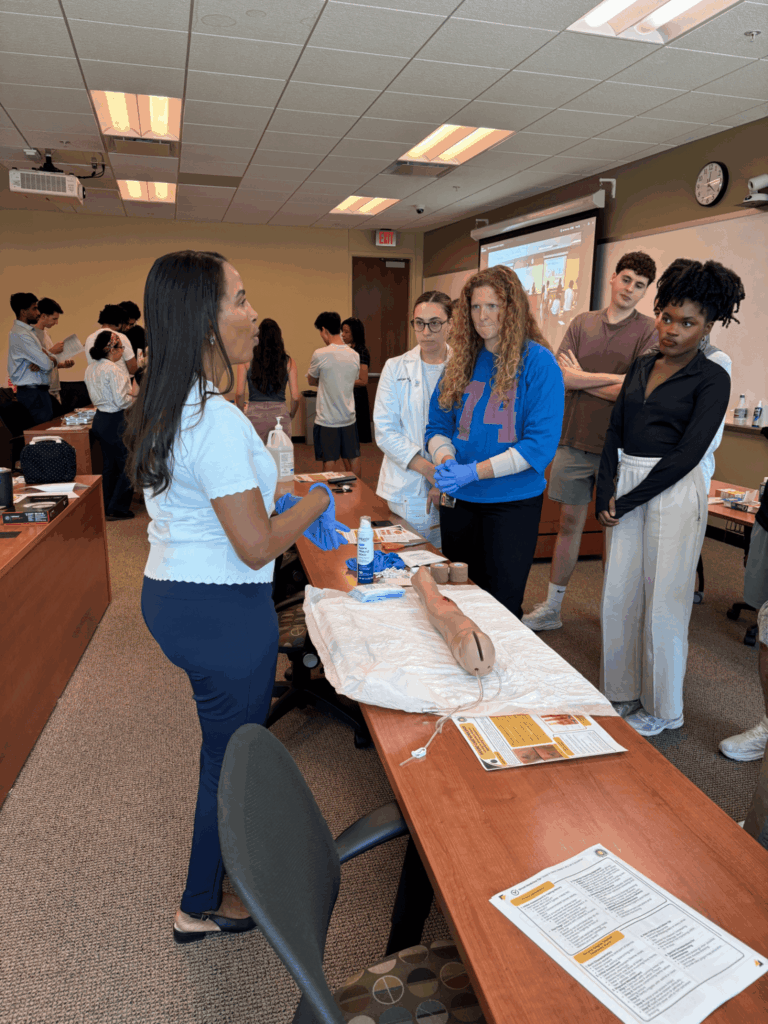 PCP Scholars learn how to dress a burn wound from Dr. Cato-Varlack in a February Wound Care Simulation Workshop.
