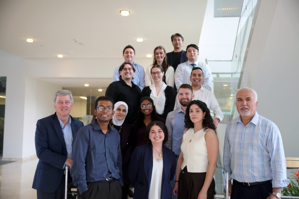 A photo of a group of faculty and students standing on stairs. 