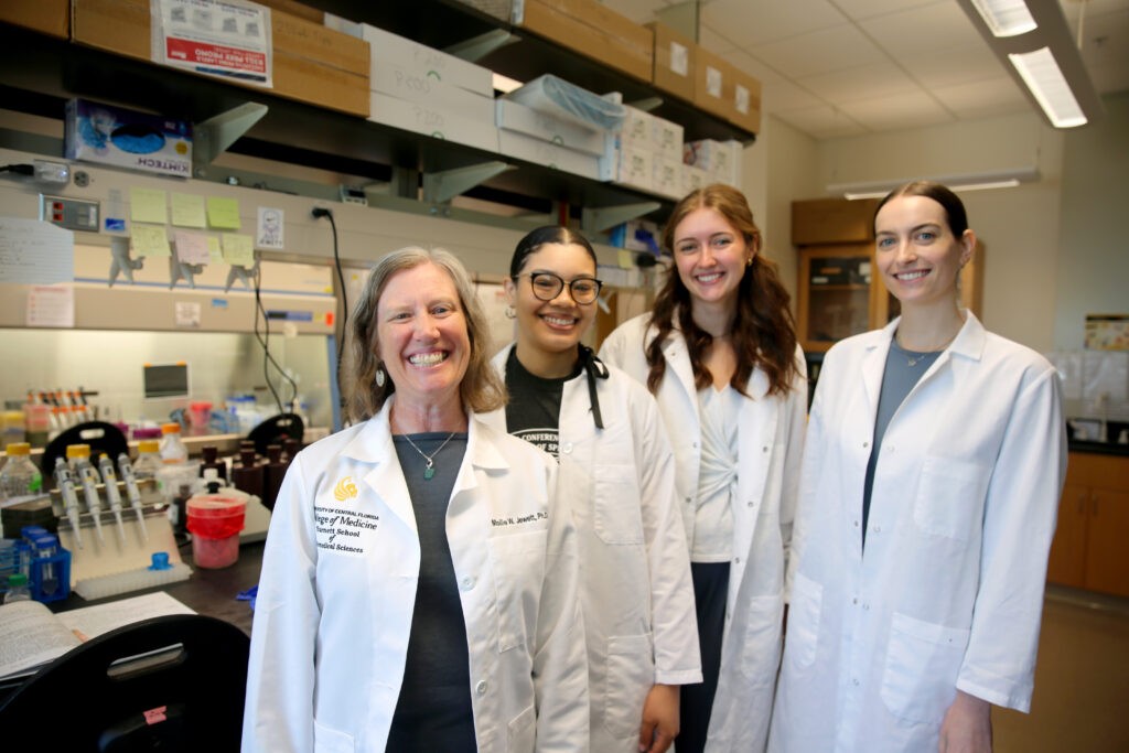Mollie Jewett and her three student collaborators standing in the lab.